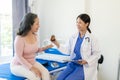 Asian female doctor talks to patient with smile to encourage patient at hospital An elderly