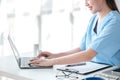 Asian female doctor working on laptop, filling out paperwork, patient medical history, reviewing documents at her Royalty Free Stock Photo