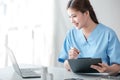 Asian female doctor working on laptop, filling out paperwork, patient medical history, reviewing documents at her Royalty Free Stock Photo