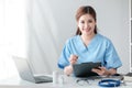 Asian female doctor working on laptop, filling out paperwork, patient medical history, reviewing documents at her Royalty Free Stock Photo