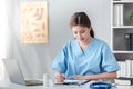 Asian female doctor working on laptop, filling out paperwork, patient medical history, reviewing documents at her Royalty Free Stock Photo