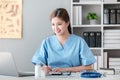 Asian female doctor working on laptop, filling out paperwork, patient medical history, reviewing documents at her Royalty Free Stock Photo