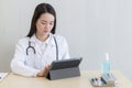 Asian female doctors use tablets to consult information Royalty Free Stock Photo