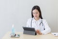 Asian female doctors use tablets to consult information Royalty Free Stock Photo