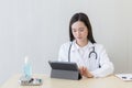Asian female doctors use tablets to consult information Royalty Free Stock Photo