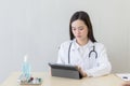 Asian female doctors use tablets to consult information Royalty Free Stock Photo