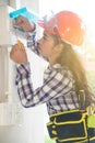 Asian female Electrician or Engineer check or Inspect Electrical system circuit Breaker. Royalty Free Stock Photo