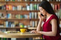 Asian female entrepreneur talking on cellphone in cafe and using digital tablet Royalty Free Stock Photo