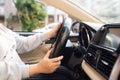Asian female hands on the steering wheel of a car while driving with windshield and road. Black woman hands holding a steering Royalty Free Stock Photo