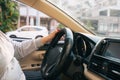 Asian female hands on the steering wheel of a car while driving with windshield and road. Black woman hands holding a steering Royalty Free Stock Photo