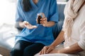 Female hands touching old female hand Helping hands holding bottle with pills in hands, reading instruction take care of the Royalty Free Stock Photo