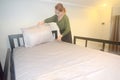 Asian female hostel maid setting up white pillow. Royalty Free Stock Photo