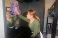 Asian female maid or housekeeper cleaning on glass of dressing table. Royalty Free Stock Photo