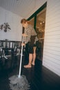 Asian female maid smiling Cleaning Service with Mop cleaning floor on shop. Royalty Free Stock Photo