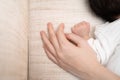 Asian female mother hand holding baby infant hand on bed when sleeping. protection and care from parent concept. Royalty Free Stock Photo