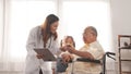 Asian female nurse tells how to take medicine to elderly senior grandfather patient Royalty Free Stock Photo