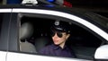 Asian female officer riding in car, monitoring traffic law and order in city Royalty Free Stock Photo