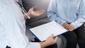 Asian female Patient listening intently to a male doctor explaining symptoms about health complaints in her home, health care Royalty Free Stock Photo