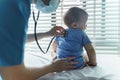 Asian female Pediatrician doctor examining her little baby patient with stethoscope in medical room Royalty Free Stock Photo