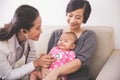 Asian female pediatrician examining a baby girl in the mother la Royalty Free Stock Photo