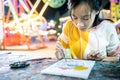 Asian female people is concentrating on paint and determined to learn art,happy teenage girl with palette and paintbrush to Royalty Free Stock Photo