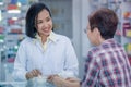 Asian female pharmacist or doctor explaining prescription medicine to patient female in a pharmacy Royalty Free Stock Photo