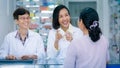 Asian female pharmacist or doctor explaining prescription medicine to patient female in a pharmacy Royalty Free Stock Photo