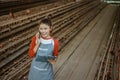 Asian female poultry farmer chats on a cell phone call Royalty Free Stock Photo