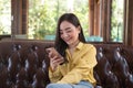 Asian female reading text message or social media on cell telephone during in modern cafe Royalty Free Stock Photo