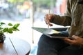 Asian female remote working at the cafe, working on her tasks on tablet. cropped image Royalty Free Stock Photo