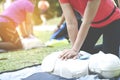 Asian female or runner woman training CPR demonstrating class in park by put hands and interlock finger over CPR doll give chest Royalty Free Stock Photo