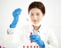 Female scientist looking at test tube