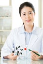 Asian female scientist teacher point at molecular model explain Royalty Free Stock Photo