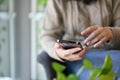 An Asian female sitting in the coffee shop and using her smartphone. cropped image Royalty Free Stock Photo