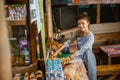 Asian female stall keeper arranges snacks on a table