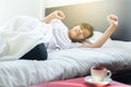 Asian female stretching and yawn on bed after wake up in the morning Royalty Free Stock Photo