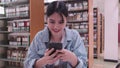 Asian female student engaging in social media via her smartphone