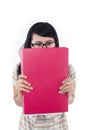 Asian female student hide behind red folder - isolated Royalty Free Stock Photo