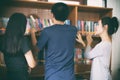 Asian female students holding for selection Book in library Royalty Free Stock Photo
