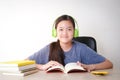 Asian female students learn online from home. Put on headphones and read a book. Royalty Free Stock Photo