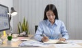 Asian female students are recording their study information in a personal notebook