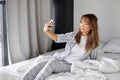 attractive asian female take photo on bed in the morning