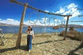 An asian female takes photos on Lake Titicaca, a large, deep lake in the Andes on the border of Bolivia and Peru. Royalty Free Stock Photo