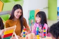 Asian female teacher teaching mixed race kids play toy in classr Royalty Free Stock Photo