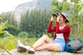 Asian female tourist enjoying nature tourism using binoculars for bird watching. Royalty Free Stock Photo