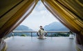 Asian female tourist in hat sitting in front of tent, Beautiful blue skies and mountains in Chiang Rai, Thailand Royalty Free Stock Photo