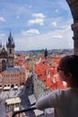 Asian female tourist looking down old town square from observatory of astronomical clock tower in Prague Royalty Free Stock Photo