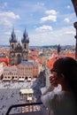 Asian female tourist looking down old town square from observatory of astronomical clock tower in Prague Royalty Free Stock Photo