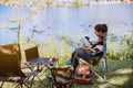 Asian female tourists camping and And working notebook, She is happy, relaxed, enjoying reading a book