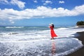 Asian female tourists look at the beautiful sea,black sand beach Bali,Indonesia.